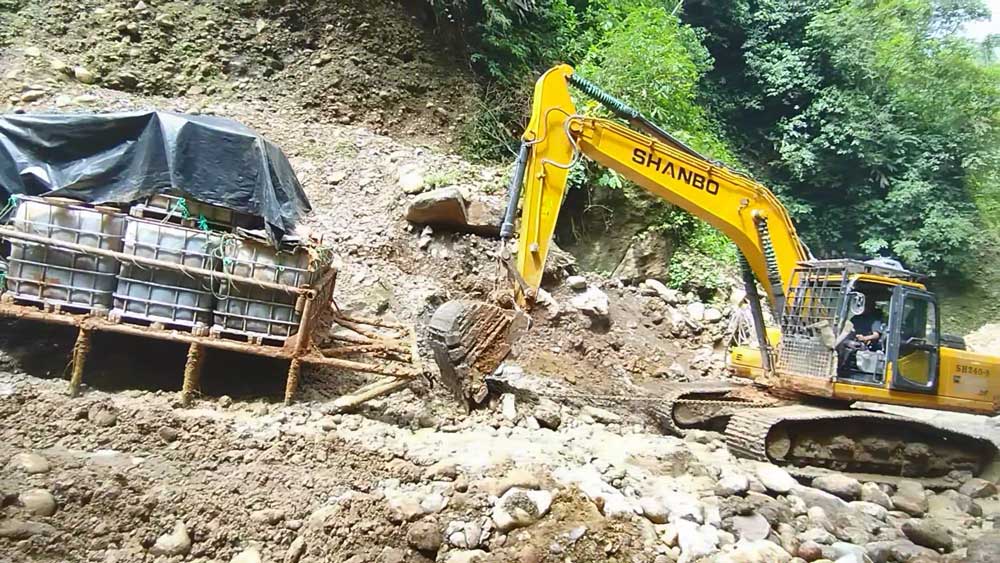Le bulldozer SH240-8 à chenilles traverse les terrains boueux de la forêt amazonienne pour transport